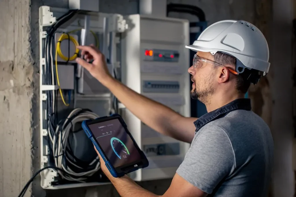 Experienced electrician using a digital multimeter to test circuit continuity on-site.